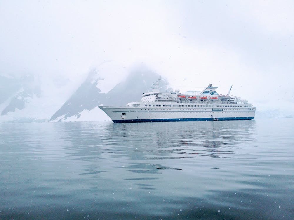 Luxury expedition cruise ship in Antarctica with icebergs and snow-covered landscape