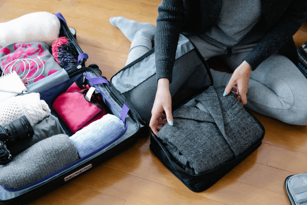 Traveler packing neatly using packing cubes and organized clothing for stress free travel.