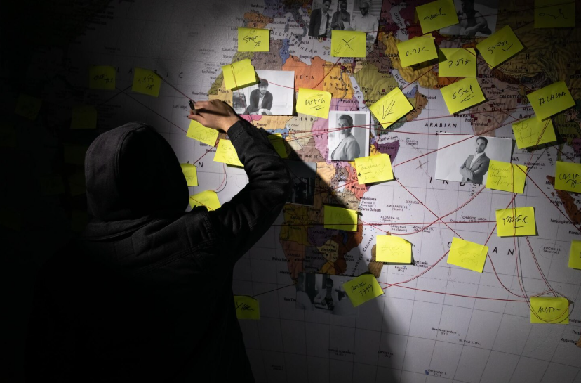 Person connecting photos and notes on a world map representing conspiracy theories and viral mystery topics.