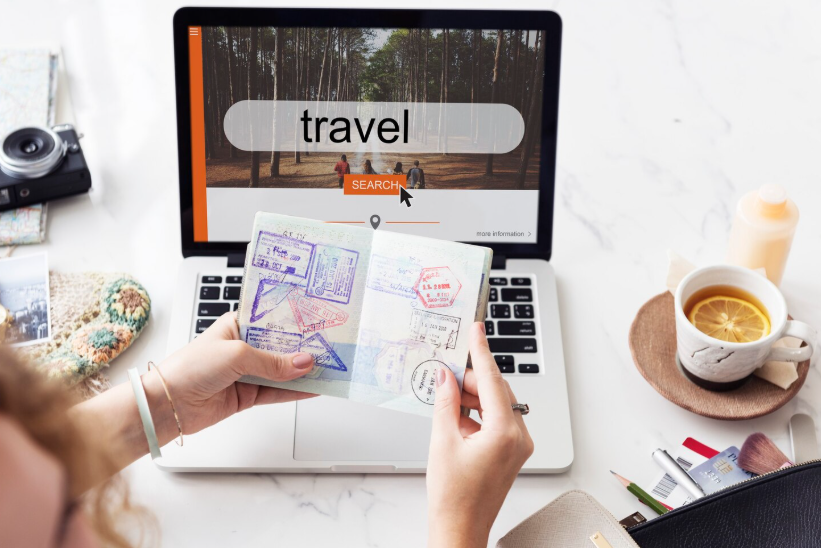 Person searching online for travel while holding a passport, showing summer travel search trends.