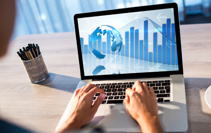 Laptop showing global economic trends and bar charts during financial analysis.